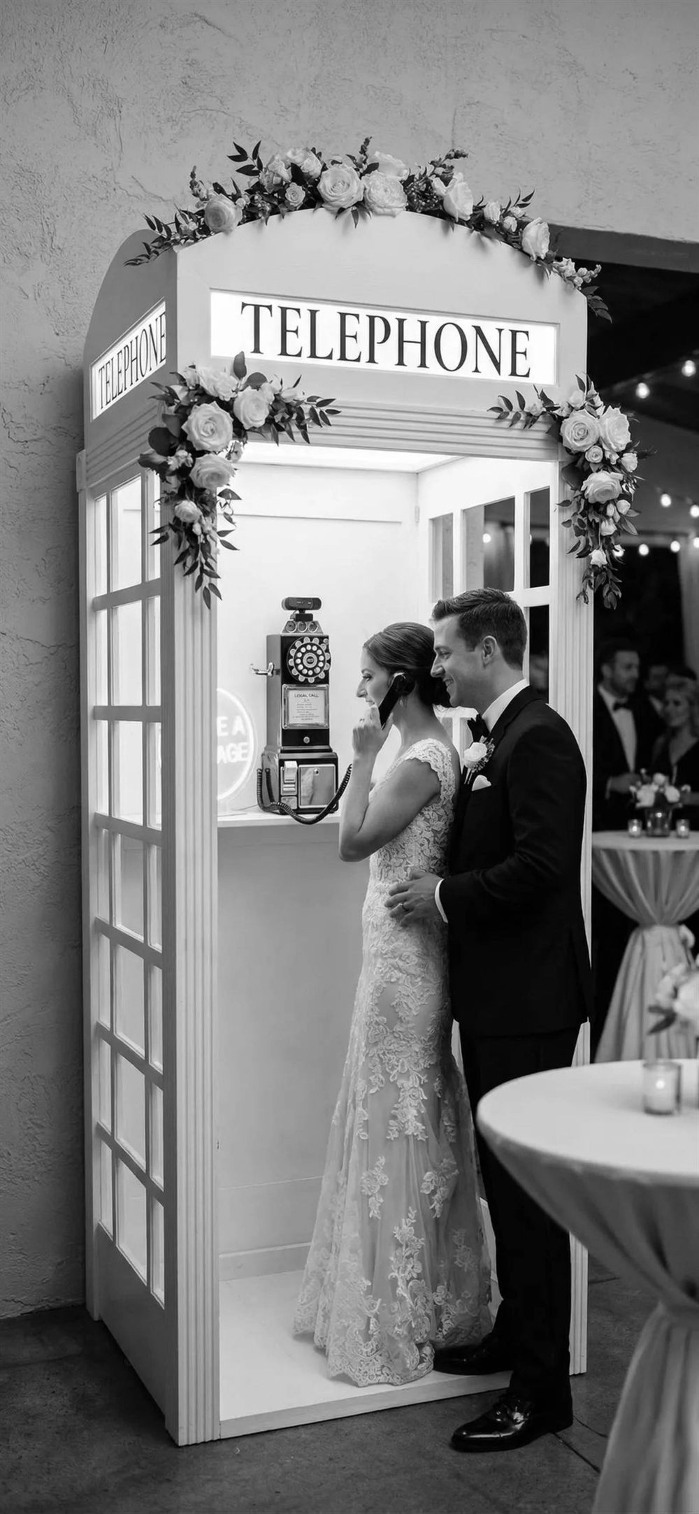 Bride and groom inside the Milestone Messages vintage phone booth
